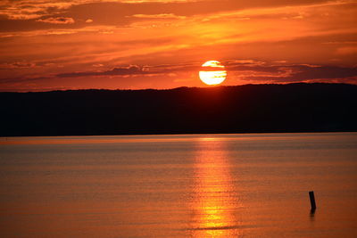 Scenic view of lake against orange sky