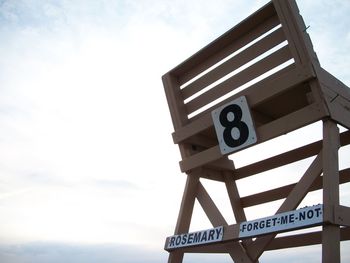 Low angle view of number on chair against sky