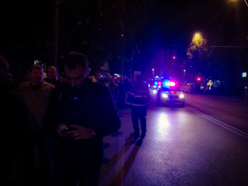 Rear view of woman standing on street at night