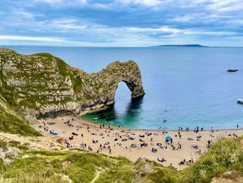 High angle view of people on durdle door beach against sky