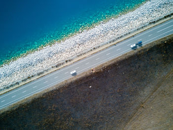 Aerial view of cars on road by sea