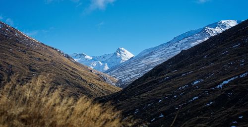 Scenic view of snowcapped mountains against blue sky