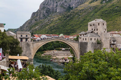 Arch bridge over buildings against mountain