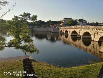 Arch bridge over river against sky