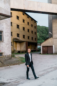 Full length of man standing against building in city