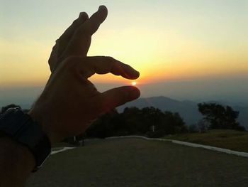 Silhouette of man on landscape against sunset sky