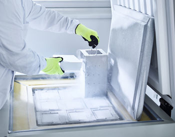 Chemist open upright freezer with gloves