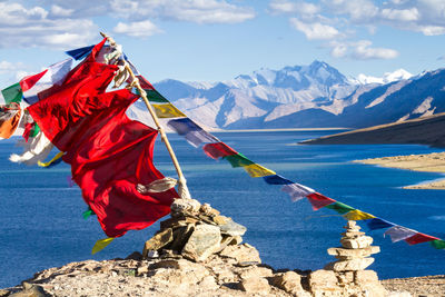 Red flag on snowcapped mountain against sky