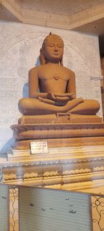 Buddha statue against wall in building