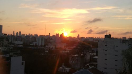 Buildings in city against sky during sunset