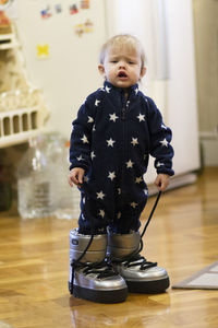 Cute boy standing on floor at home