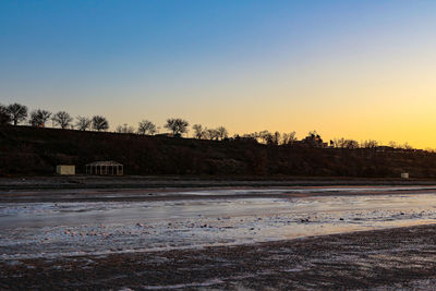 Scenic view of field against clear sky during sunset