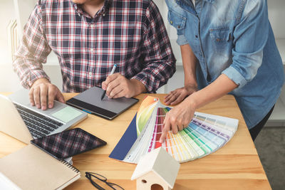 Cropped image of interior designers working at office while using graphics tablet and laptop