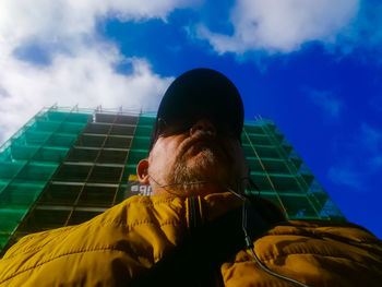 Low angle portrait of man against sky