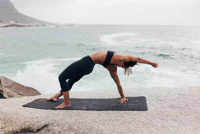 Low section of woman exercising on beach