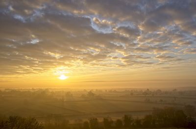 Scenic view of landscape against sky during sunrise