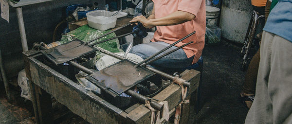 Midsection of man cooking food at don wai market