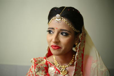 Close-up of young woman against wall