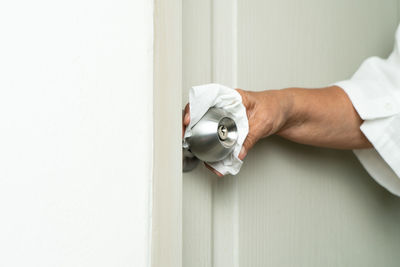 Close-up of man holding white door