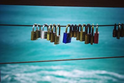 Love padlocks hanging on cable against river