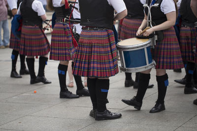 Low section of marching band wearing traditional clothing