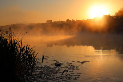 Scenic view of lake against sky during sunset