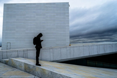 Full length of man walking against sky in city