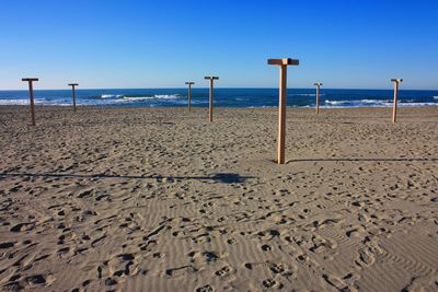 Scenic view of beach against clear blue sky