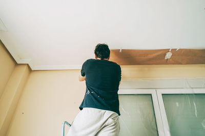 Rear view of man standing against wall