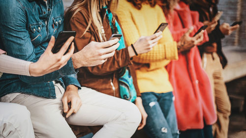 Midsection of people sitting on street