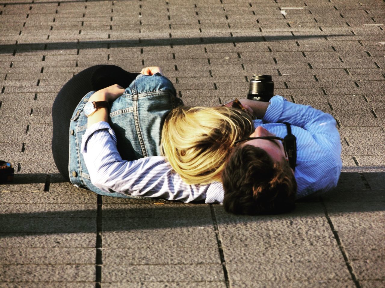 two people, lying down, heterosexual couple, outdoors, togetherness, real people, leisure activity, high angle view, couple - relationship, lifestyles, day, casual clothing, men, women, bonding, relaxation, young women, young adult, friendship, adult, people, adults only