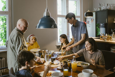 Multi-generation family having dinner at dining table in home