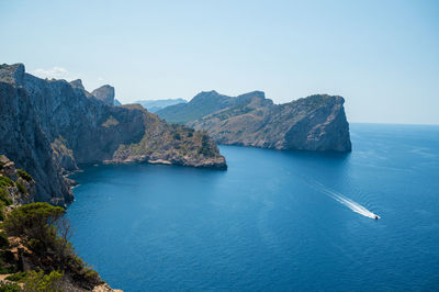 Scenic view of sea and mountains against clear sky