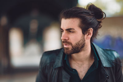 Portrait of young man looking away outdoors