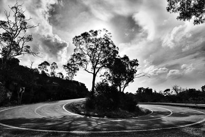 Empty road against cloudy sky