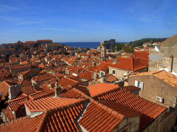 High angle view of houses in town against clear blue sky