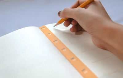 Close-up of woman hand writing in book