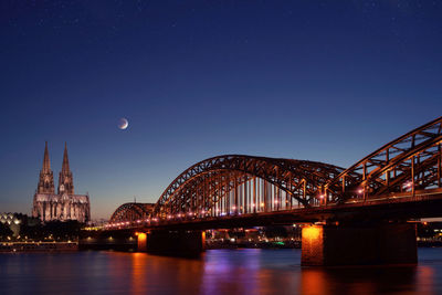 View of bridge over river at night