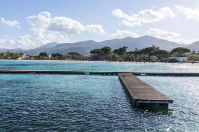 Scenic view of pier in sea against cloudy sky