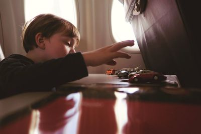 Boy playing with toy cars while traveling in airplane