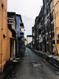 Narrow street amidst buildings against sky