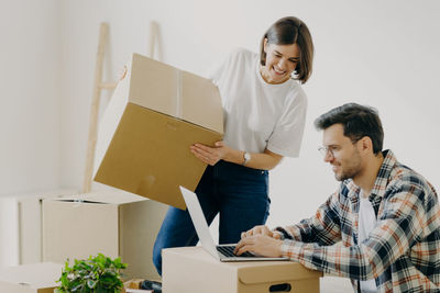 Couple with cardboard boxes at new home