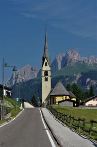 Road amidst buildings against sky