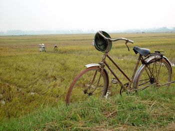 Bicycles on field against clear sky