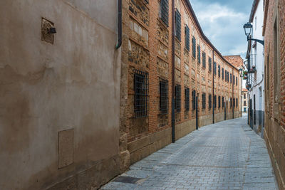 Narrow street amidst buildings against sky