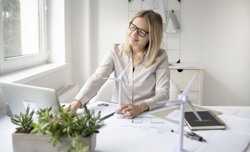 Woman working with smart phone while sitting on table