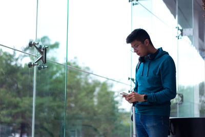 Side view of young man using mobile phone