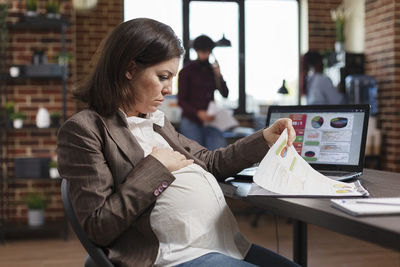 Pregnant businesswoman working at office