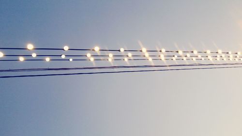 Low angle view of illuminated street light against clear sky