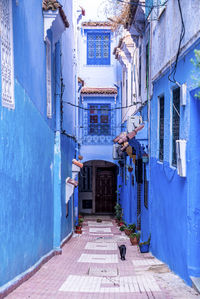Narrow alley of blue town with residential structures on both side